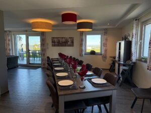 The long dining table with high chairs and a view of the terrace